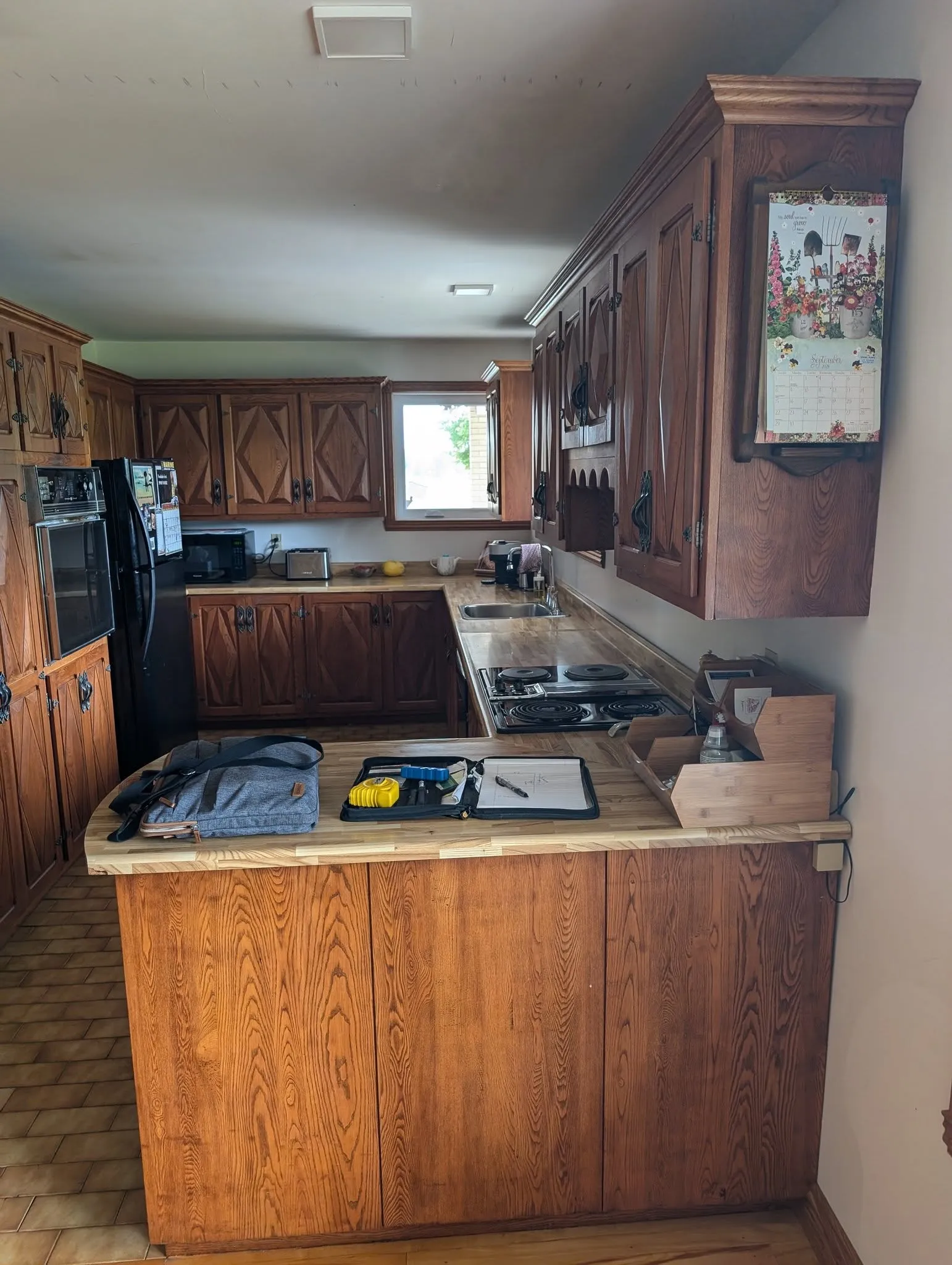 La cuisine avant les travaux, avec ses armoires en bois foncé
